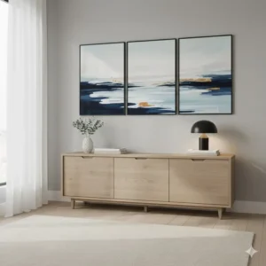 A set of three calming blue and white abstract bedroom wall prints hung horizontally above a dresser.