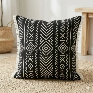 Illustration 3: A square black boho pillow with a white geometric mudcloth pattern.