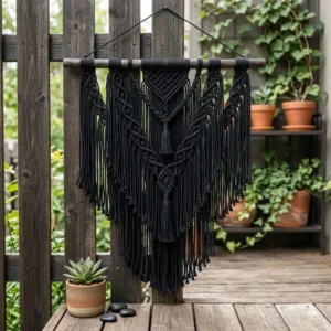 Weather-resistant black macrame decor styled on a wooden patio wall for a chic outdoor space.