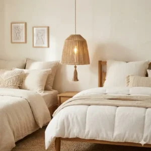 A soft-glow bohemian pendant light made of natural jute hanging in a cozy minimalist bedroom.